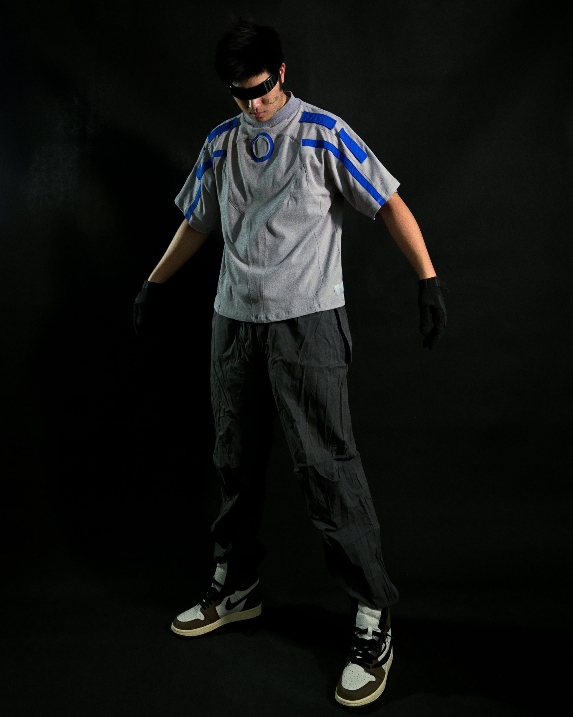 Grey grid cybercore cyberpunk underground fashion tee, front model standing view