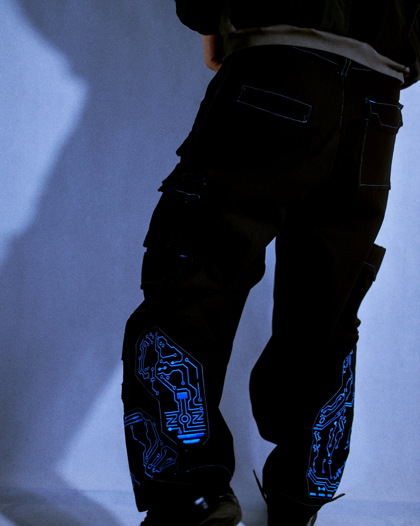 black denim grid futuristic techno circuit cyborg pants, model on body view