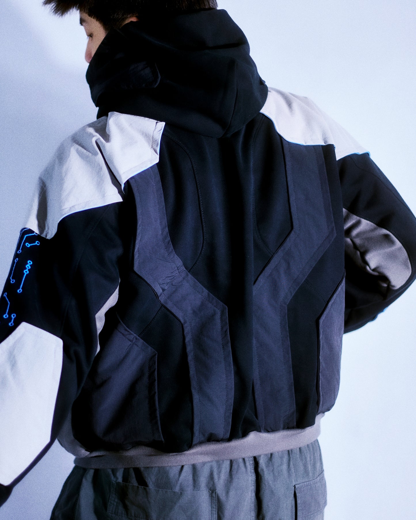 Black hoodie with futuristic grid tech wear style, back model view