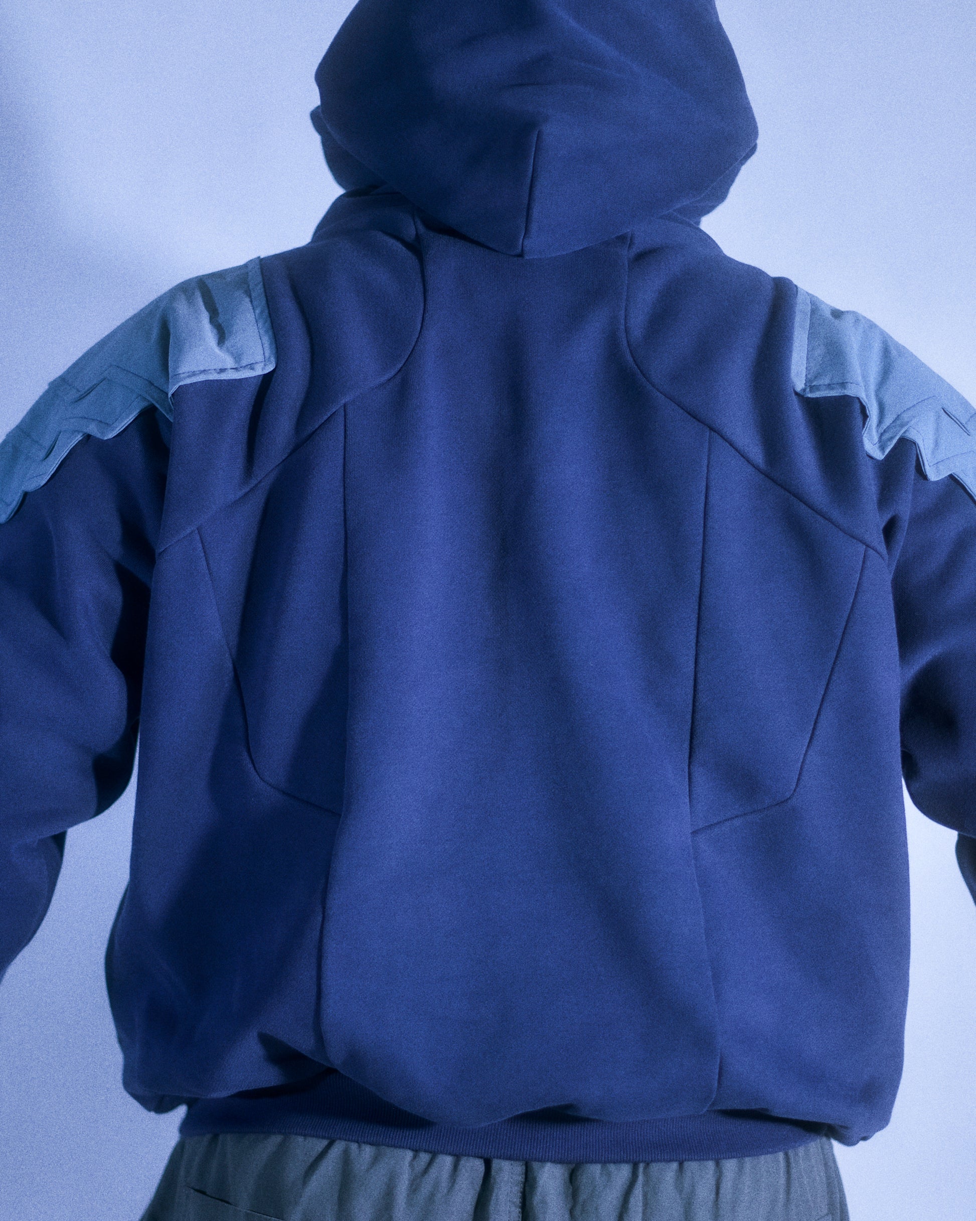 Navy hoodie with cyberpunk armor details, back model view